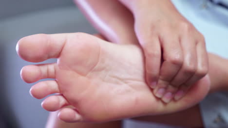 close-up of an individual squeezing her foot from the toes to her heel to get some relief from inflammation and pain