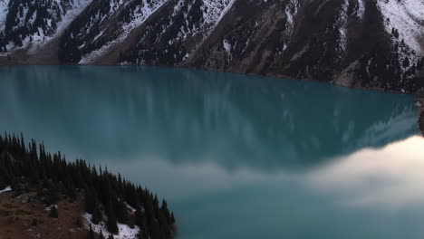 drone circling over the reflecting surface of the big almaty lake, in kazakhstan