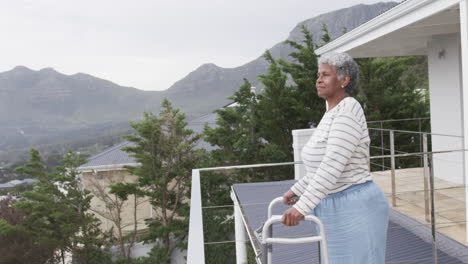 senior african american woman with walking frame on balcony, copy space, slow motion