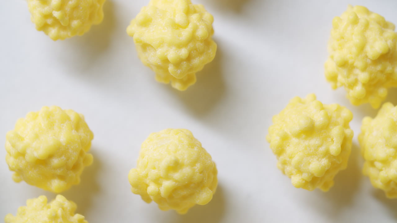 밝은 형태의 흰색 표면에 있는 노란색 바이러스 세포의 매크로 샷 왼쪽