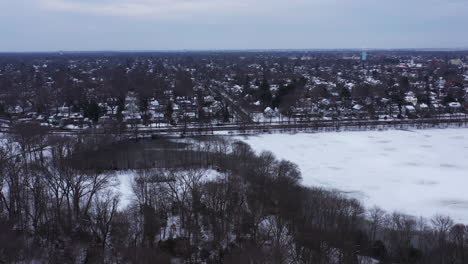 an aerial view from a drone, over a long lake during sunrise on a cloudy morning