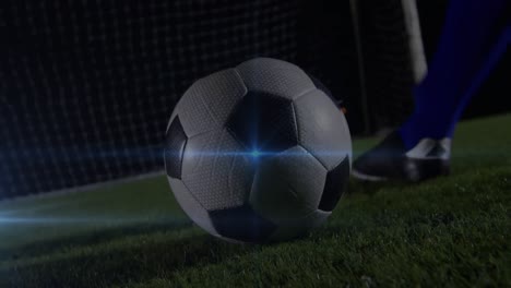 Animation-Eines-Blauen-Lichtflecks-Im-Unteren-Bereich-Eines-Männlichen-Fußballspielers,-Der-Den-Ball-Tritt