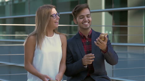 pareja feliz usando teléfonos celulares y tomando selfies
