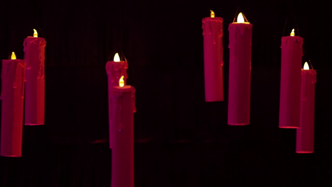 Floating candles with black backdrop (fast panning). Red and pink colors.