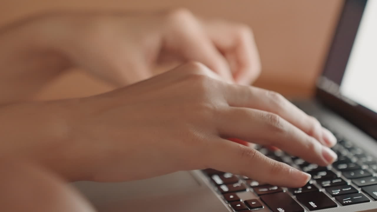 Professional working environment with steady keystrokes. Individual carefully editing slides amidst warm interior illumination. Closeup of person diligently working on laptop in calm office setting
