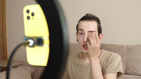 A person applying makeup in front of a phone