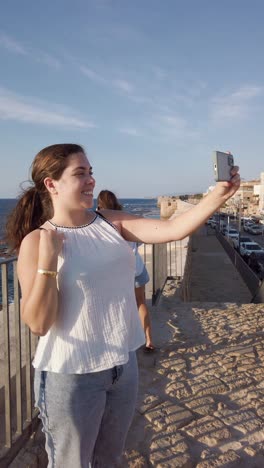 happy tourist takes a selfie by the coast in acre old city, israel.