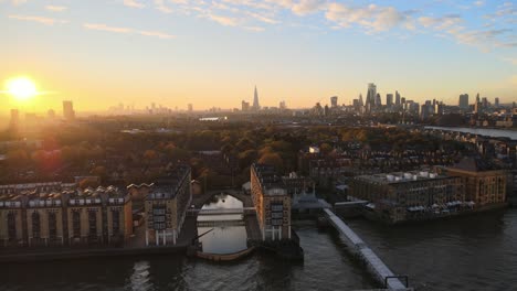luxury apartments with river thames view and beautiful skyline of london in background during golden sunset at horizon