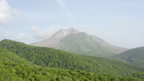 smooth dolly forward type shot. active volcano in the distance surrounded by a lush forest. part_1