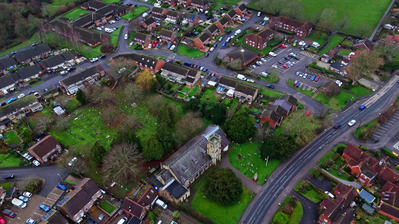aerial panning drone shot over suburban Southampton with botley village housing at sunset on an overcast cloudy winters day with cars passing by on the roads below past the small housing in the town