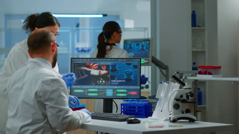 grupo de científicos que trabajan en un laboratorio modernamente equipado apuntando a la computadora