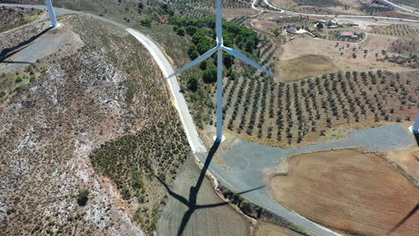 aerial view of wind turbines casting shadows on the ground, alternative renewable energy source generating electrical power for natural wind movement