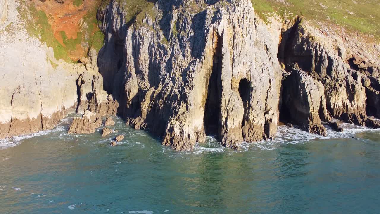 Unusual Rock Formation with Caves Carved Out in Rocks with Calm Sea and Eroding Cliffs. Travel Nature Drone Clip. Beautiful Welsh Gower Peninsula Coast