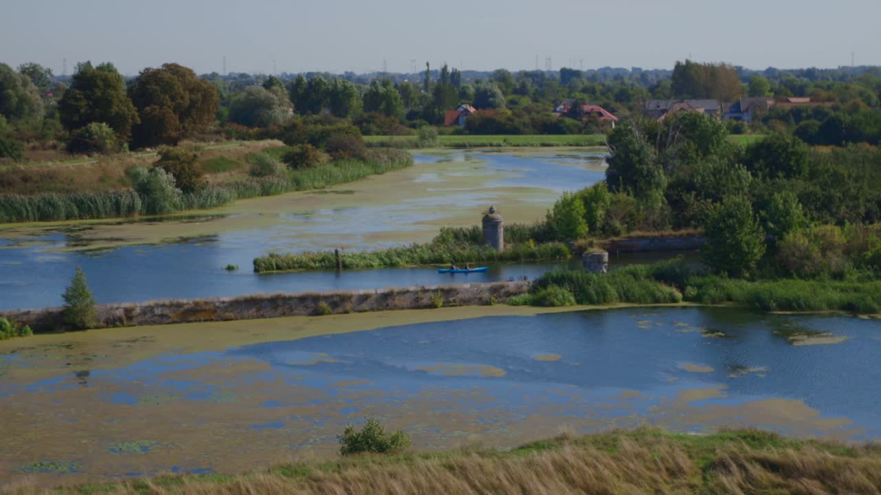 여름에 카누에서 활발한 노를 젓는 이끼 강의 넓은 샷