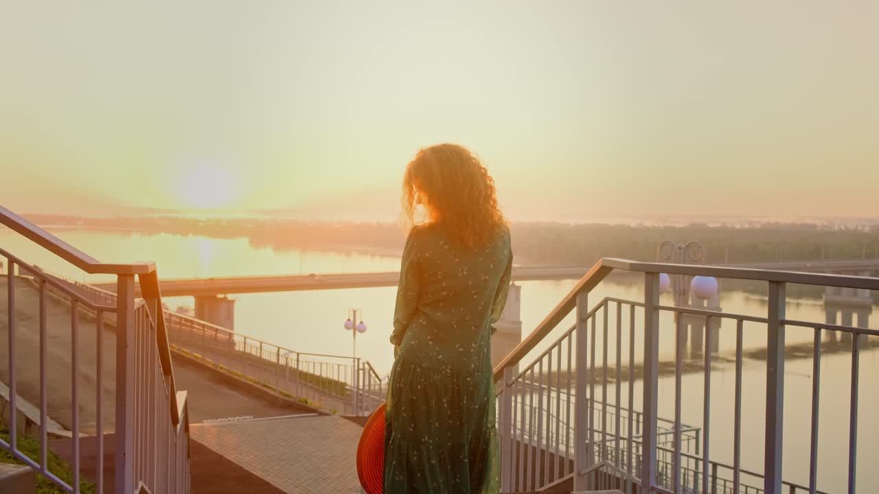Woman walking on stairs at sunrise by the river
