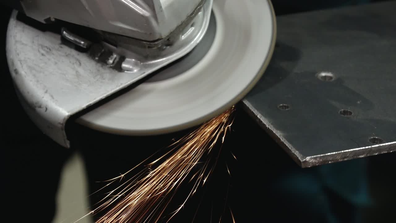 Close-up of a grinding wheel cutting or shaping a metal surface, producing vibrant sparks. A powerful depiction of industrial work and precision.