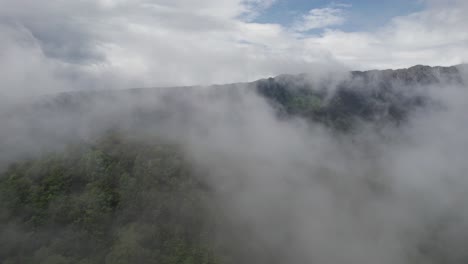 Picos-De-Montañas-Brumosos-Apenas-Visibles-A-Través-De-Una-Densa-Capa-De-Nubes,-Evocando-Misterio