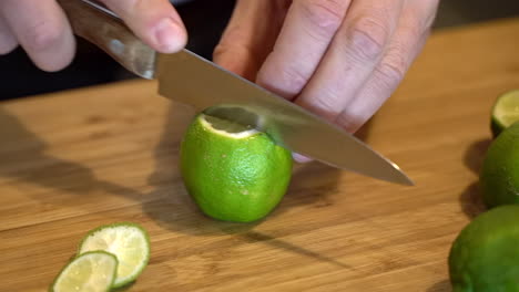 Barmann-Schneidet-Limettencocktail-Fruchtgetränk-Auf-Holztheke