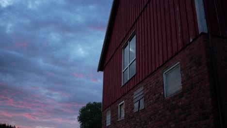 Scenic-Clouds-On-Sunset-Over-Vintage-Wooden-Farm-House