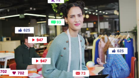 animación de iconas de las redes sociales sobre diseñadora de moda biracial con una tableta digital sonriendo
