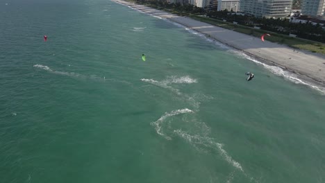 aerial: kite surfers ride onshore wind on sunny miami beach afternoon