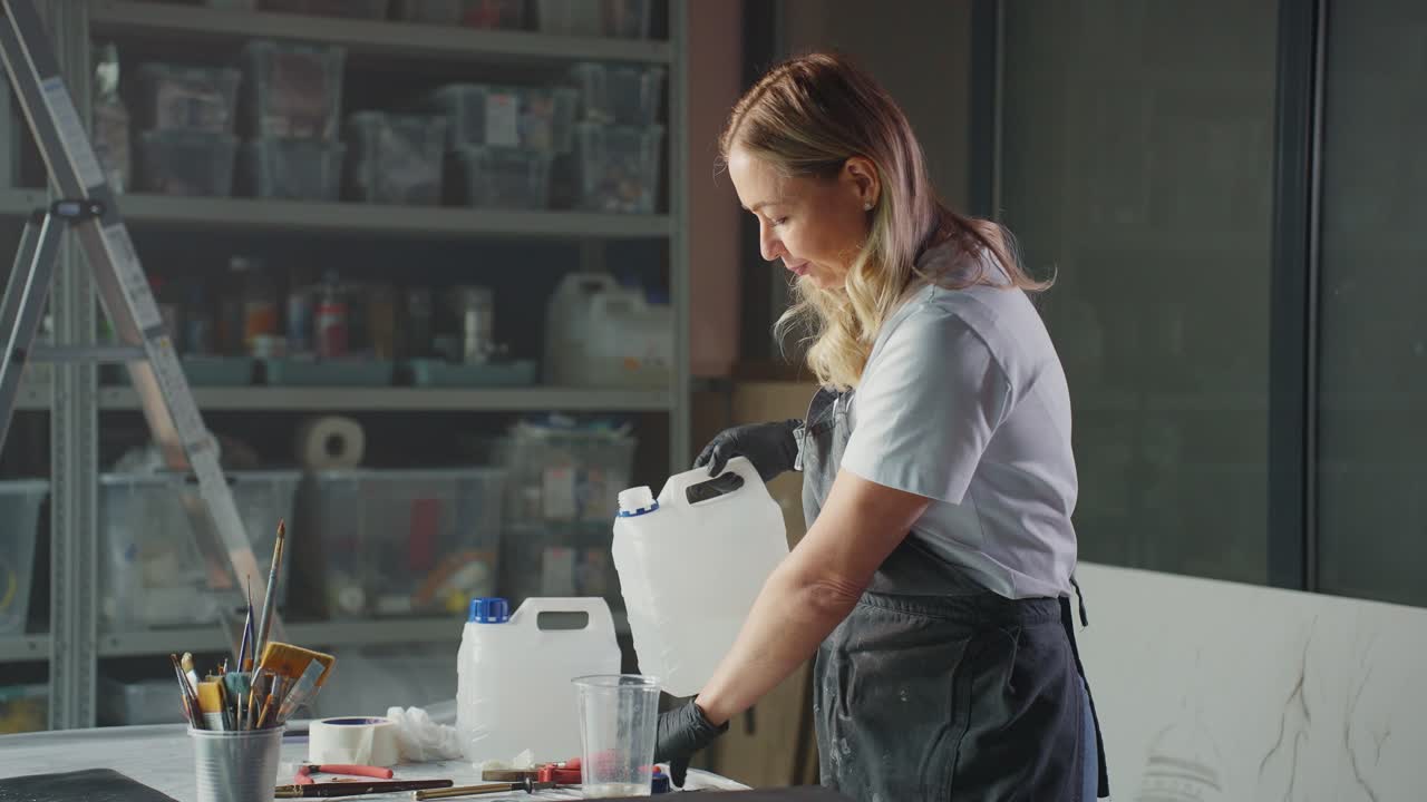 Artist Pouring Liquid in Art Studio