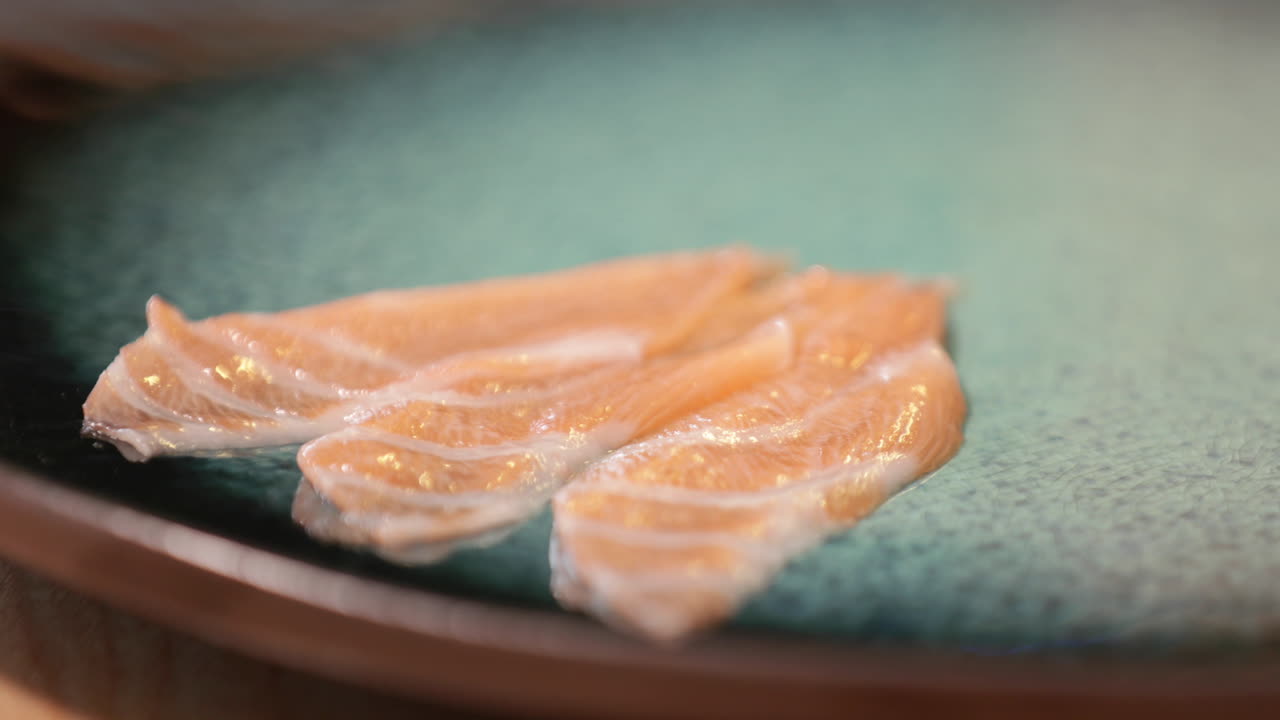 tres pedazos de sashimi de salmón en un plato