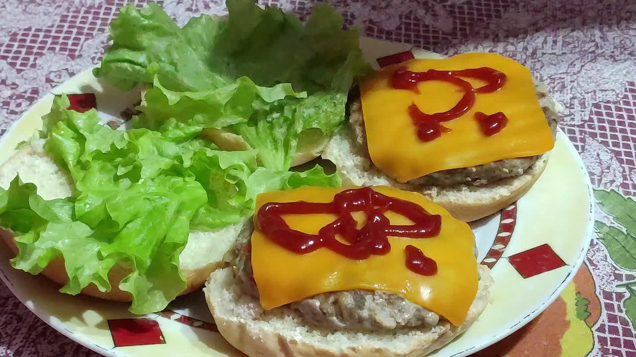 poner ketchup en dos hamburguesas en un plato sobre una mesa