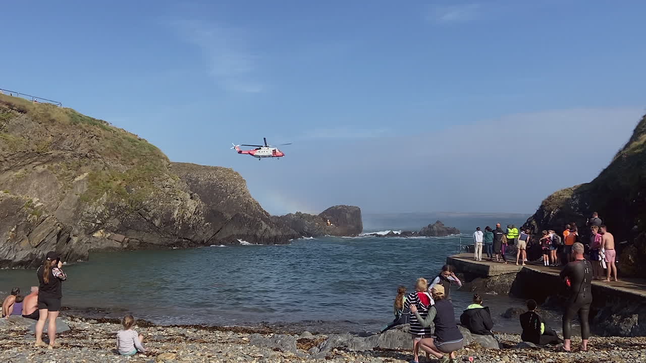 Rainbow formed as Coastguard helicopter lowers to rescue person