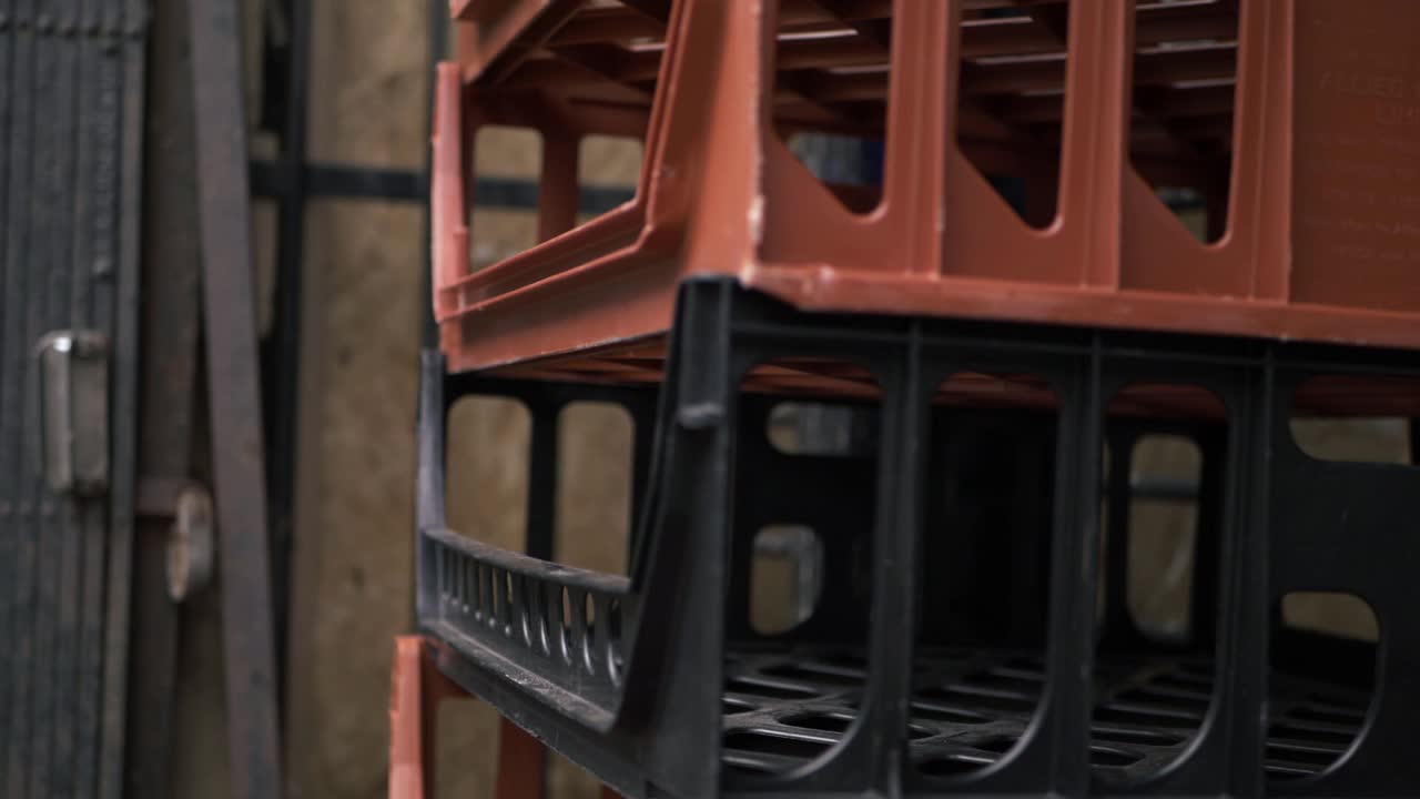 Empty bread crates stacked outside a shop close up panning shot