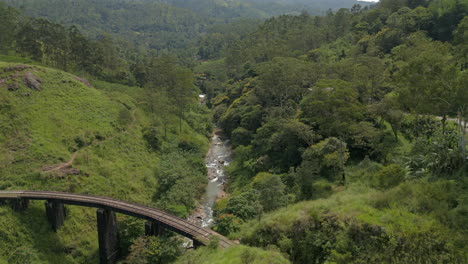 Descending-Establishing-Aerial-Drone-Shot-of-Demodara-Iron-Bridge-Looking-Down-Valley-in-Sri-Lanka-on-Sunny-Day