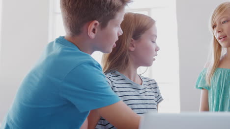 Estudiantes-Masculinos-Y-Femeninos-En-Clase-Trabajando-Juntos-En-Una-Computadora-Portátil