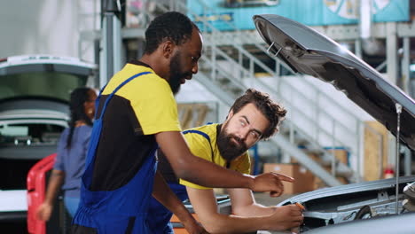 mechanics working together to fix car