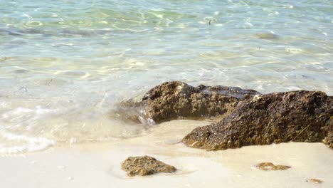 Waves-hitting-small-rocks-on-a-white-sand-beach-in-Miami,-Florida