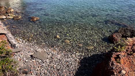 crystal clear water washing over a rocky beach on a summer day in crete greece