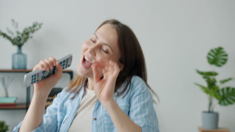 woman singing along to music with a remote