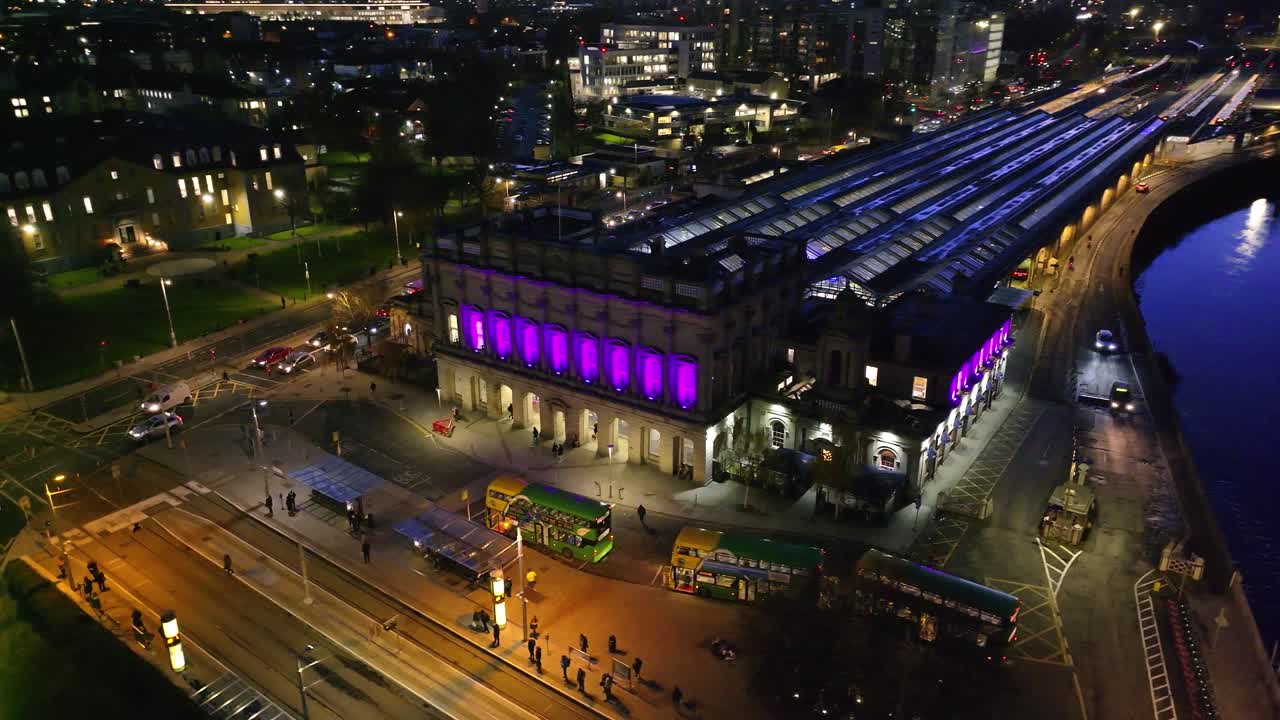 4K cinematic drone footage of Heuston Station in Dublin at sunset, highlighting the historic building, approaching trains, and the Dublin skyline under dramatic sunset hues. Dublin_032