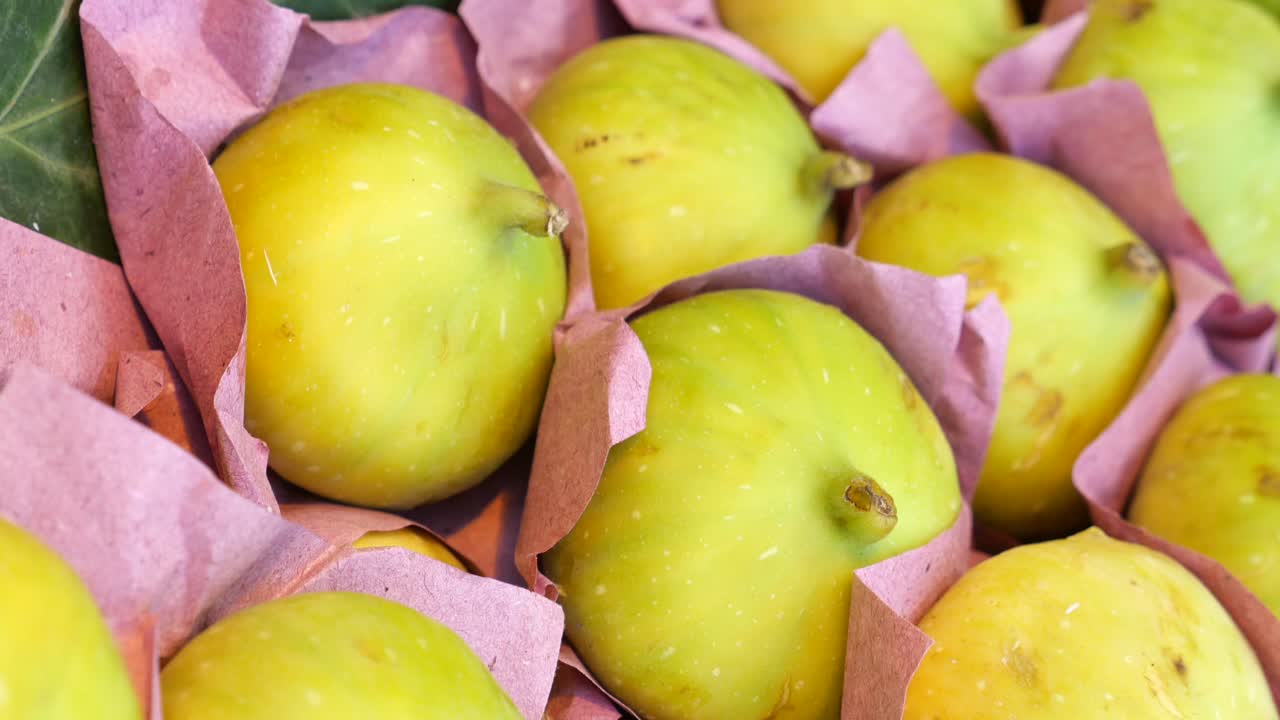 Fresh and Ripe Yellow Figs Wrapped in Pink Paper