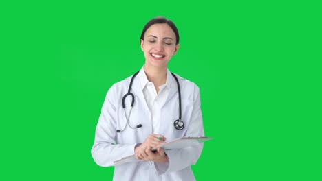 Happy-Indian-female-doctor-writing-medicines-for-patient-Green-screen