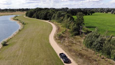 a game keeper drives along a country path in suffolk, uk