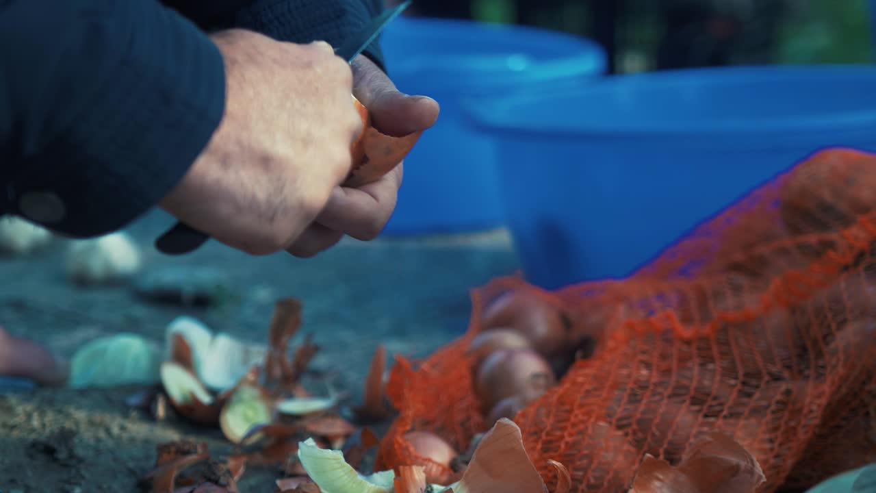 야외에서 실시간으로 양파 껍질을 벗기고 있는 남자