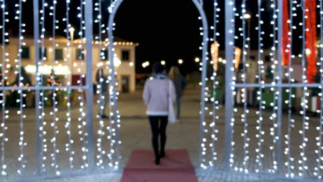 shot from behind woman walk out of focus on christmas light decoration frame