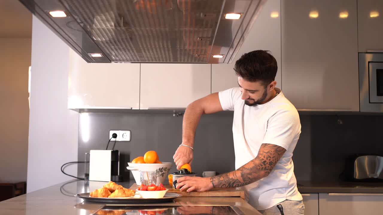 Man Making Fresh Orange Juice in Kitchen
