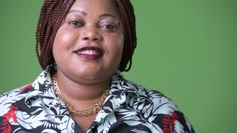 mujer africana hermosa con sobrepeso contra un fondo verde