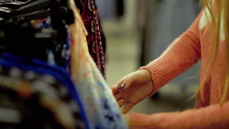 Young-beautiful-girl-chooses-clothes-in-a-supermarket