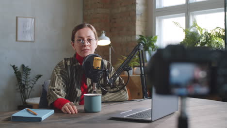 female vlogger speaking on camera in recording studio