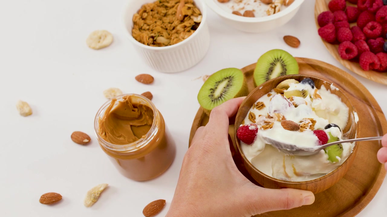 Person Eating Healthy Yogurt Bowl with Fruit and Granola