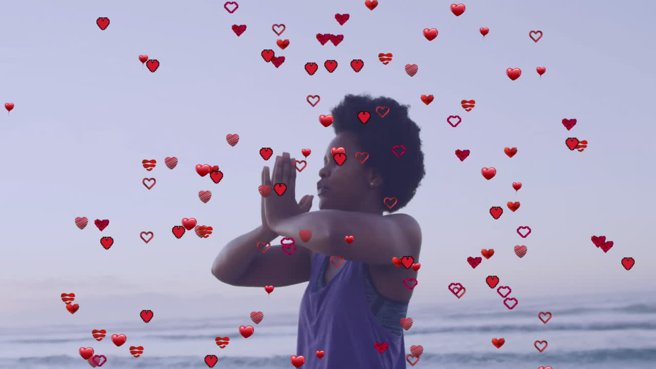 Practicing yoga on beach, person with animation of hearts overlaying scene
