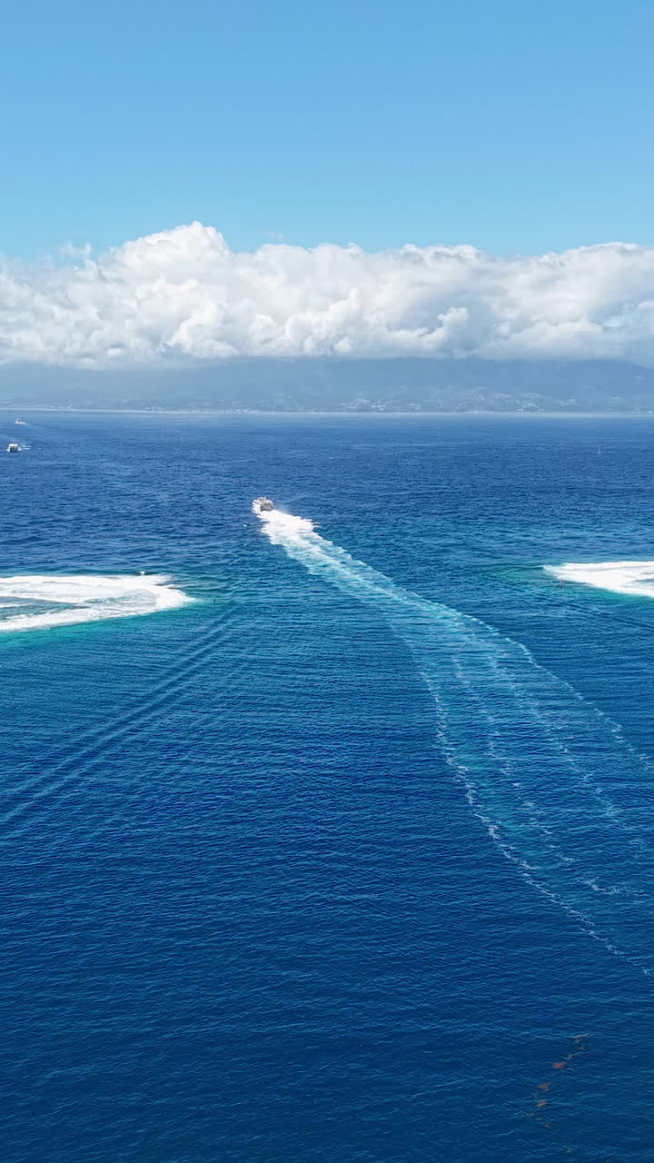 Moorea Island , French Polynesia. Vertical Drone Shot of Ferry Boat Leaving Lagoon in Coral Barrier