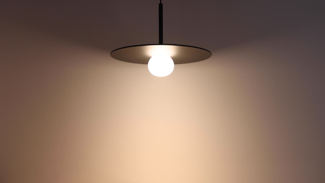 The lamps in the room are turned on and the room lights up, Lamp hanging from ceiling, Modern interior.